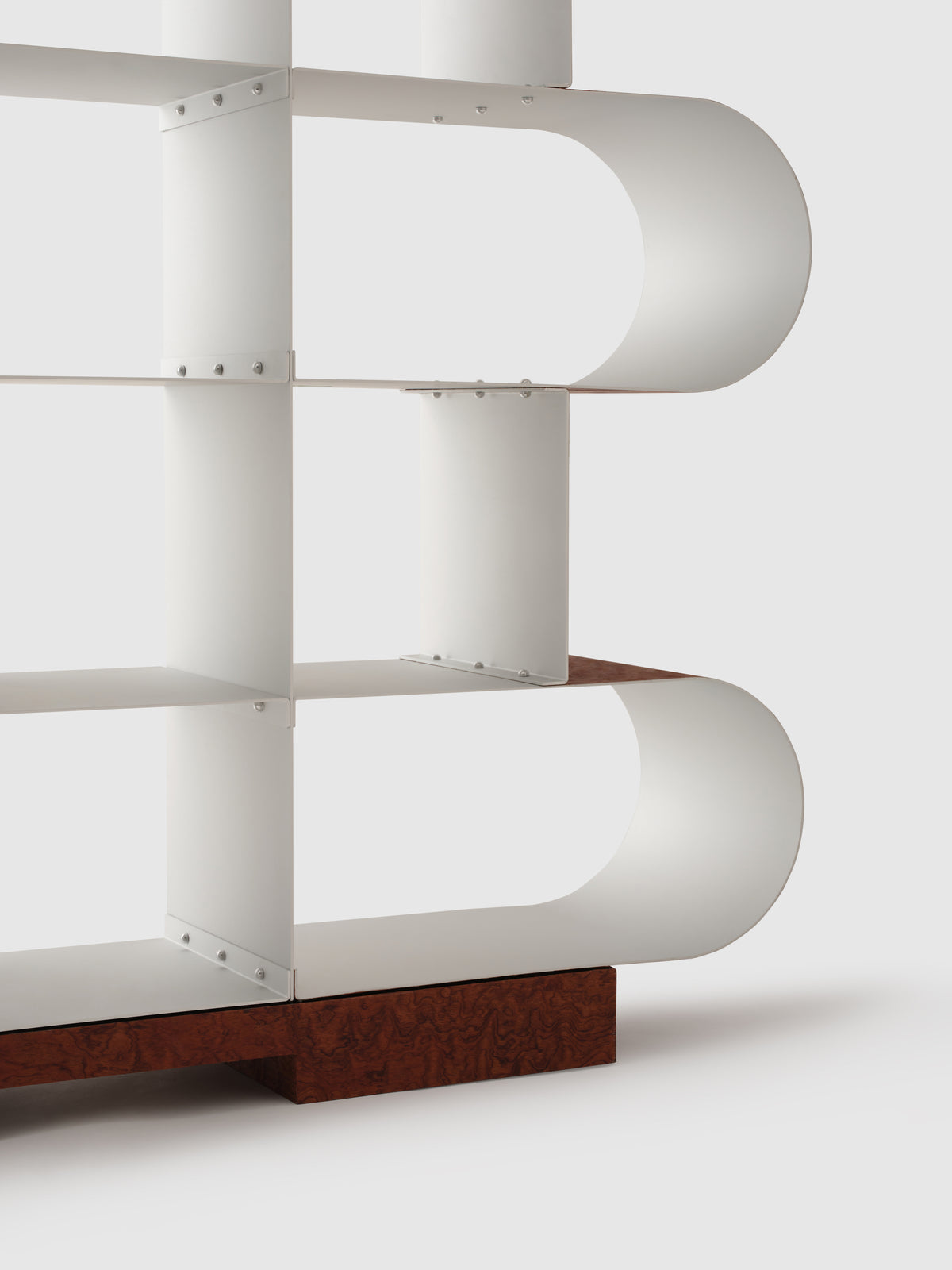 Curved aluminum shelf detail showing rounded edges and wooden base