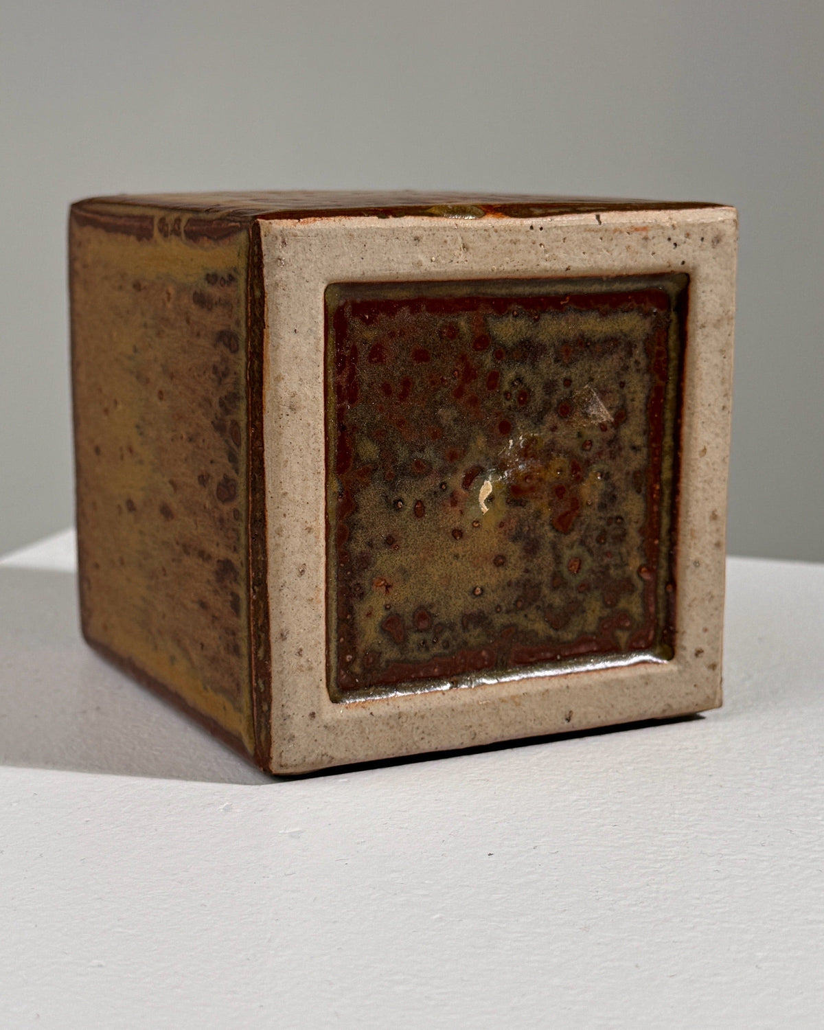 Square ceramic vase with mottled green glaze and cream frame detail