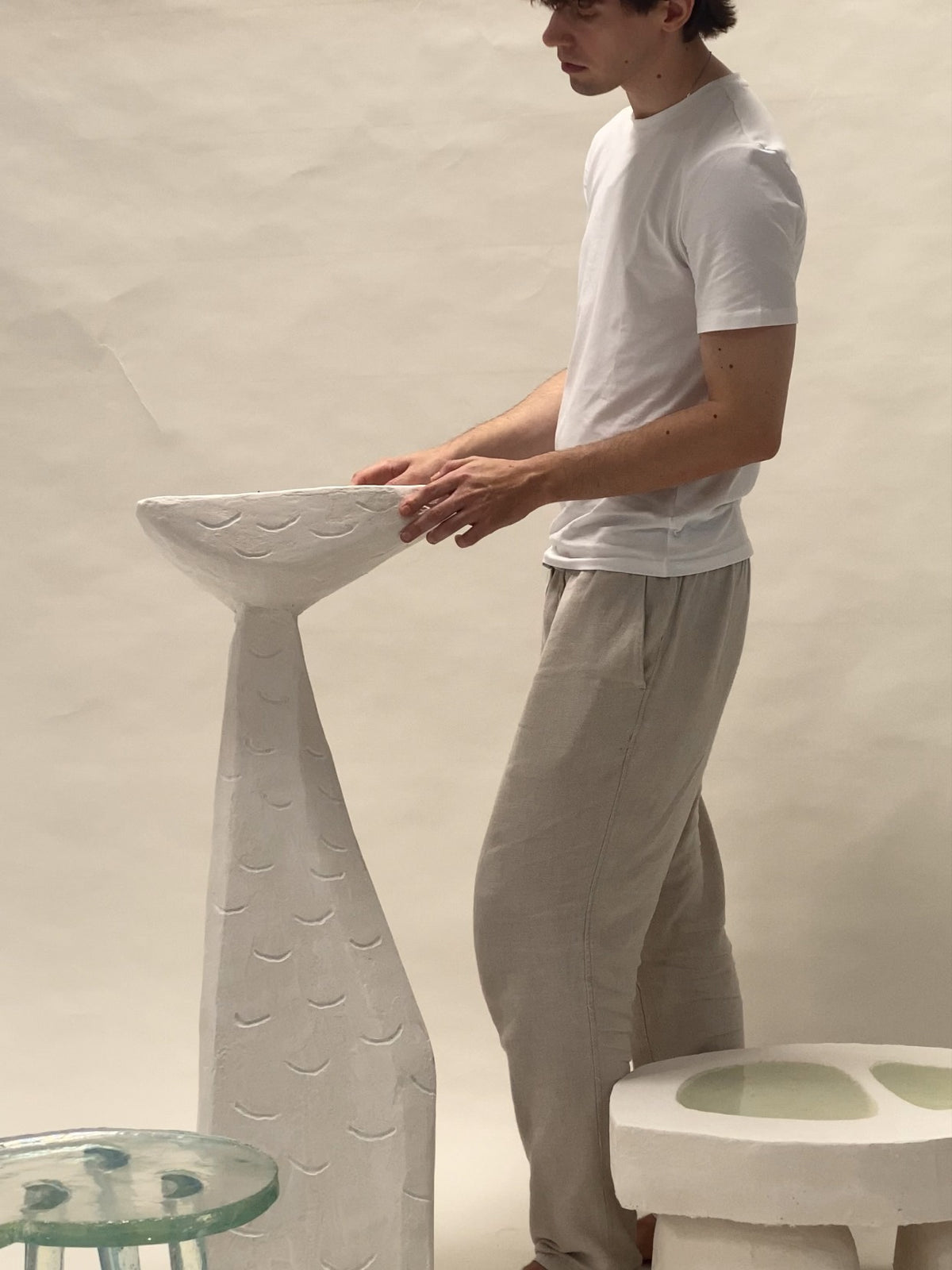 White ceramic side table with sculptural base and crescent moon pattern