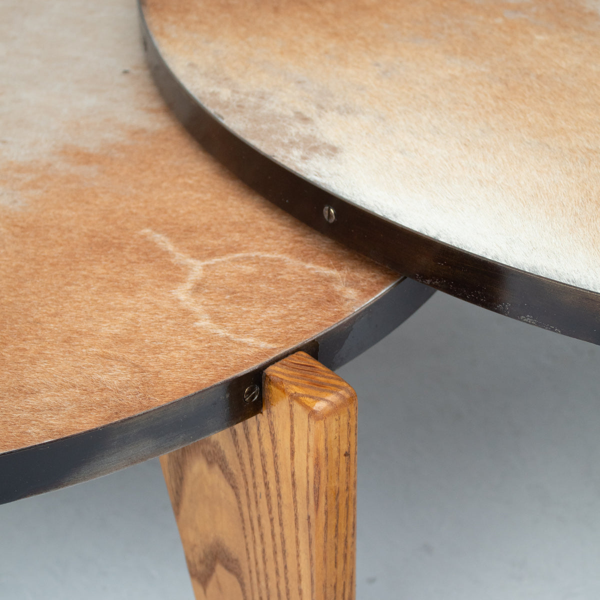 2 Coffee Tables in Wood and Cowhide — top view showing cowhide surface and wooden legs