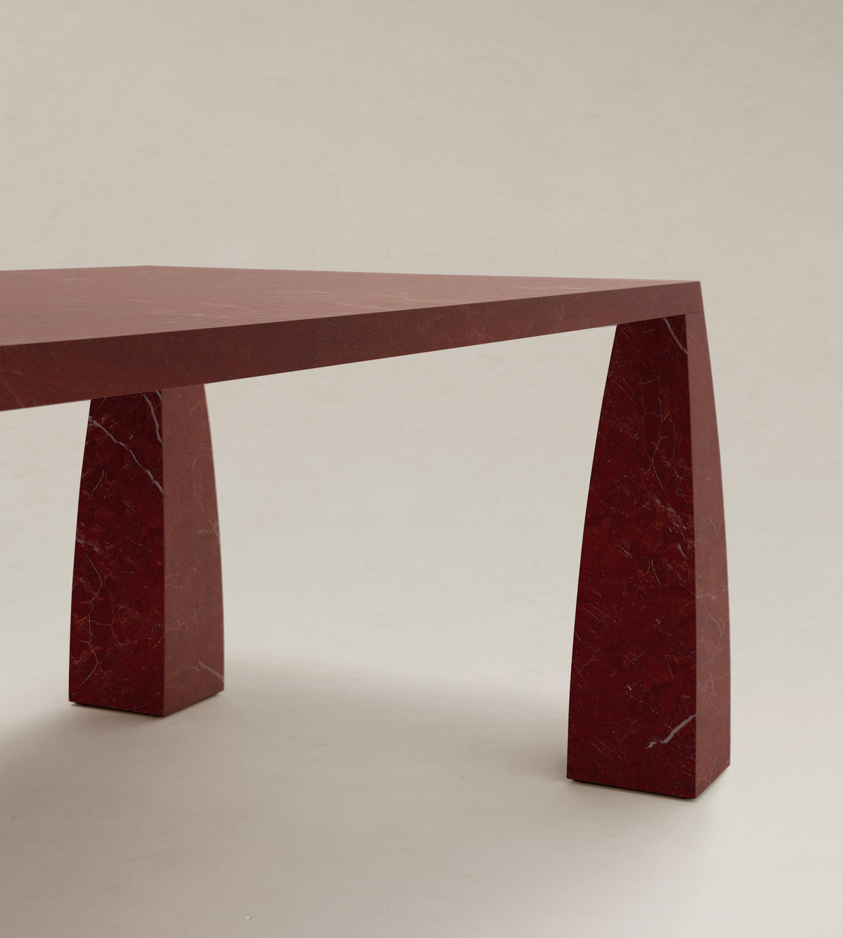 Khram Dining Table — top view of red marble surface and legs