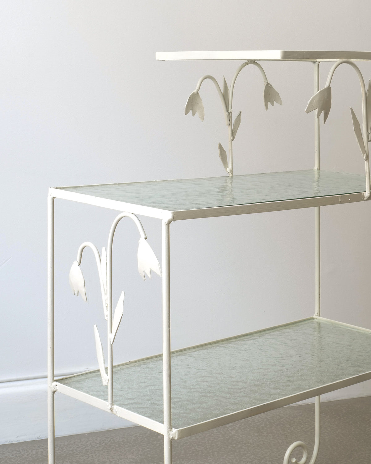 White metal tiered side table with floral cutout details