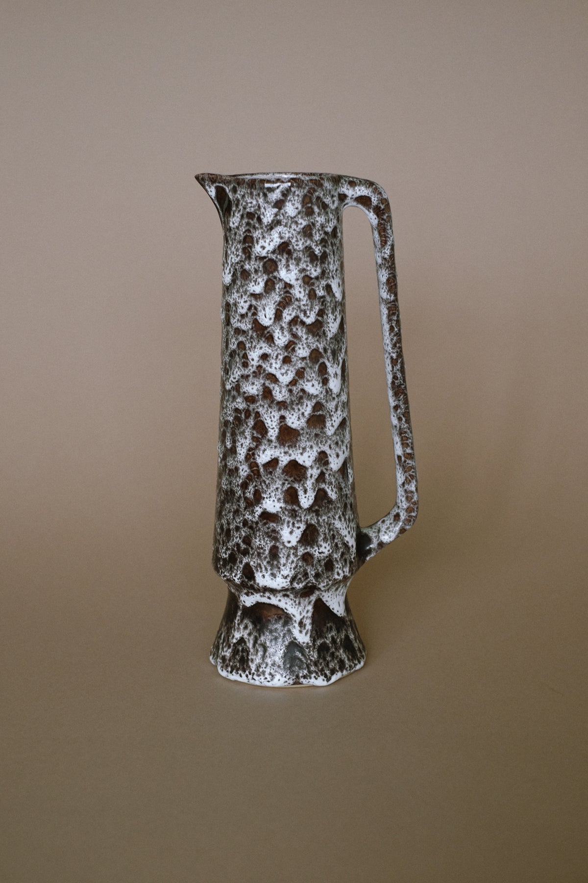Textured stoneware pitcher with speckled brown and white glaze