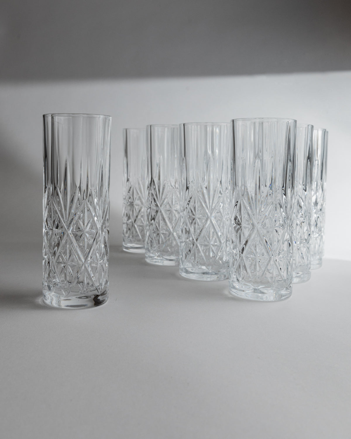 Crystal cut glasses arranged on white surface showing diamond pattern detail