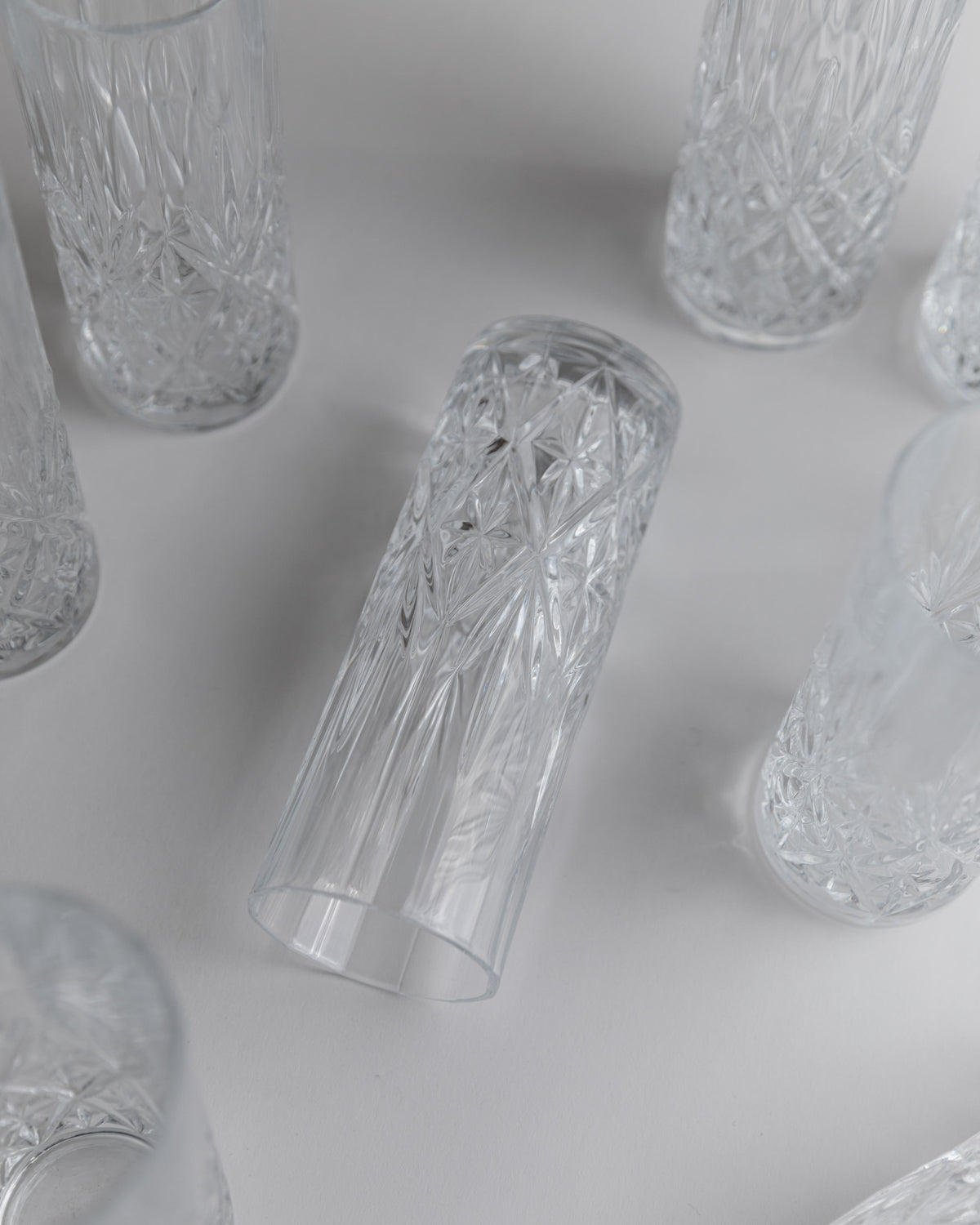 Cut crystal glasses scattered on white surface showing intricate patterns
