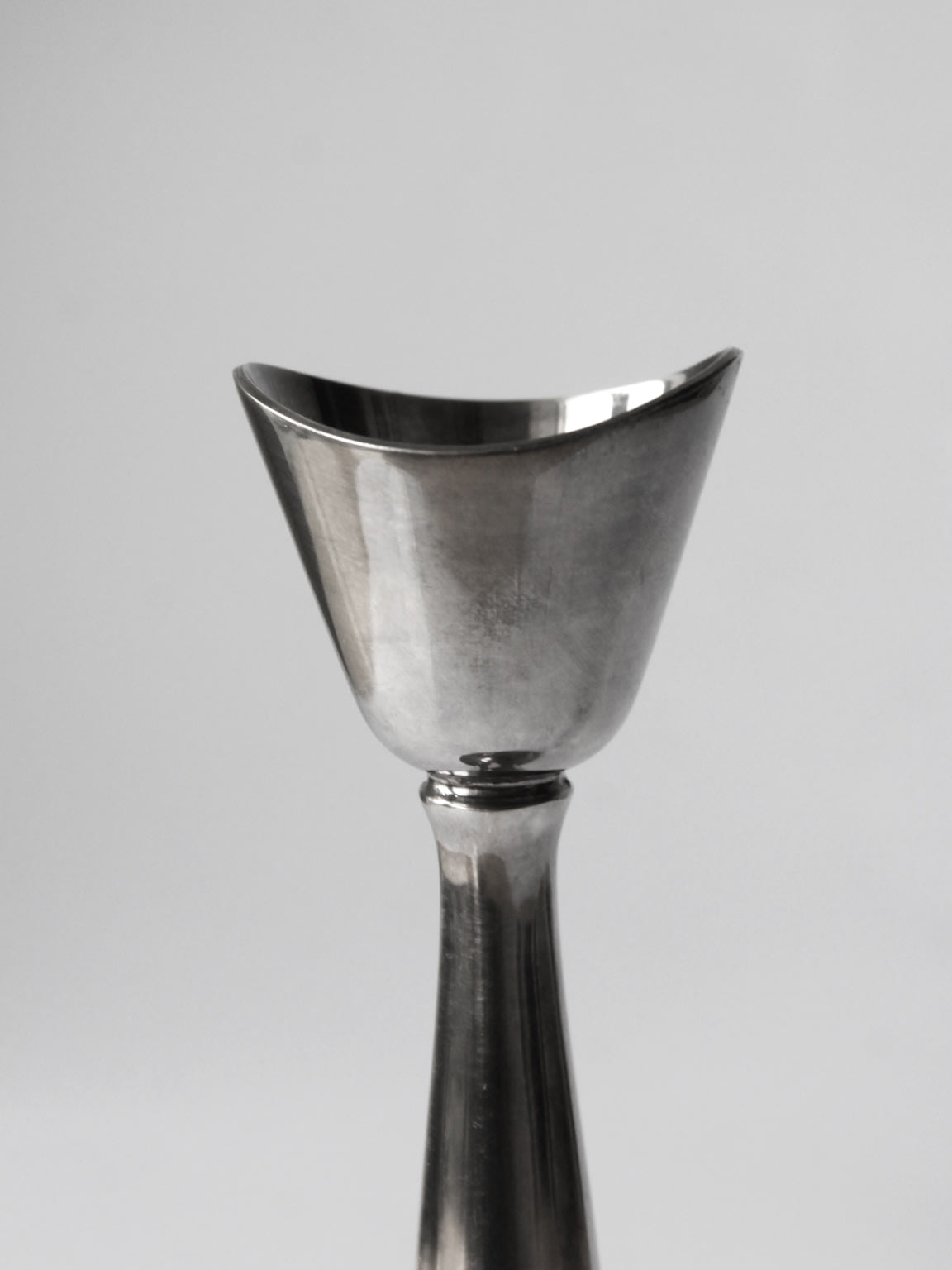 Close-up detail of silver-plated candlestick cup and stem junction
