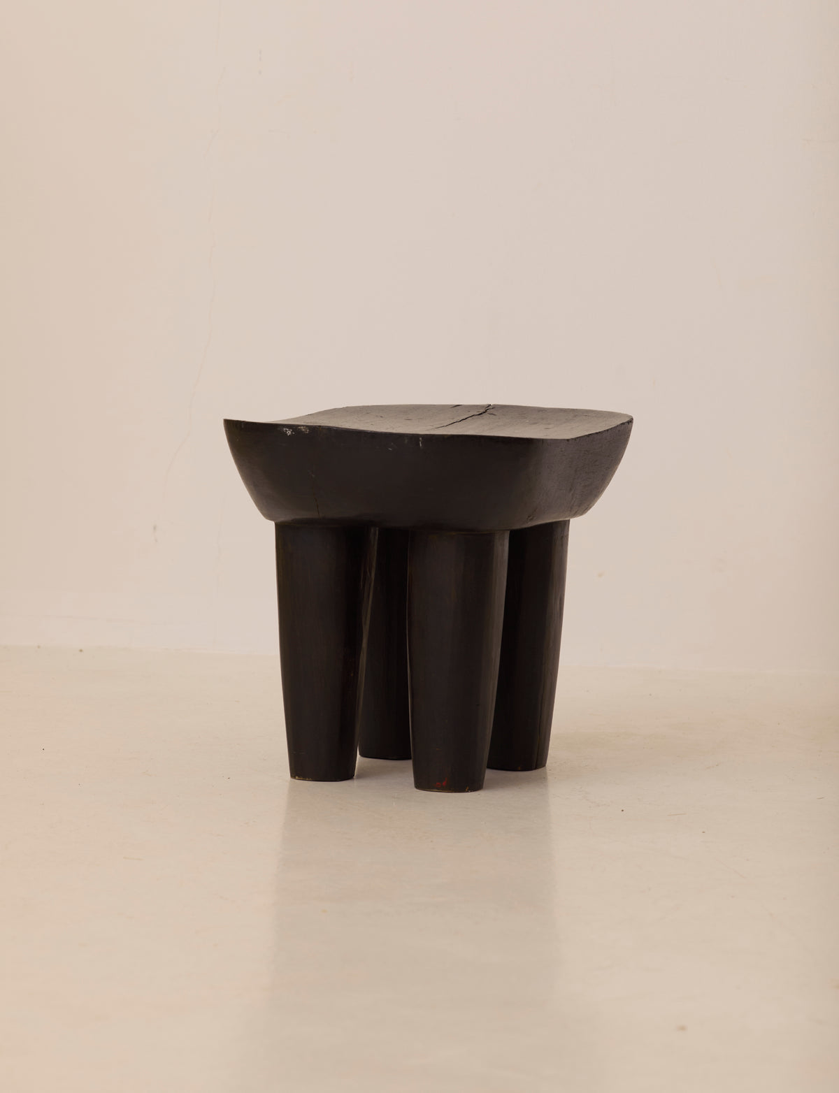 Vintage Senufo Monoxyl African Stool in Black / Wenge — angled view highlighting sturdy wooden legs