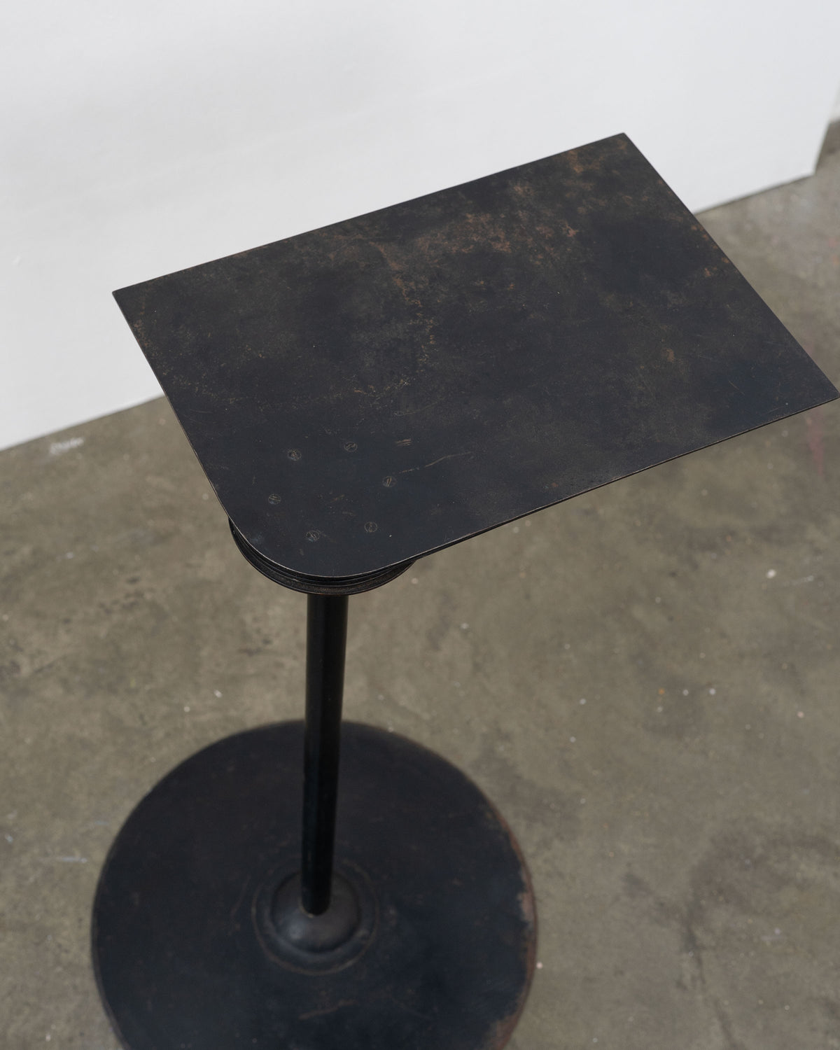 Weathered black side table with pedestal base, Pierre Chareau style