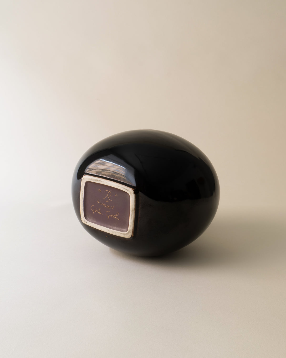 Black ceramic apple vase by Gösta Grähs showing base maker's mark