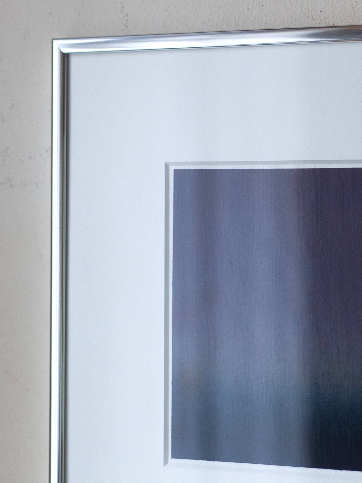 Detail of silver frame and white mat surrounding abstract painting by Rebecca von Matérn