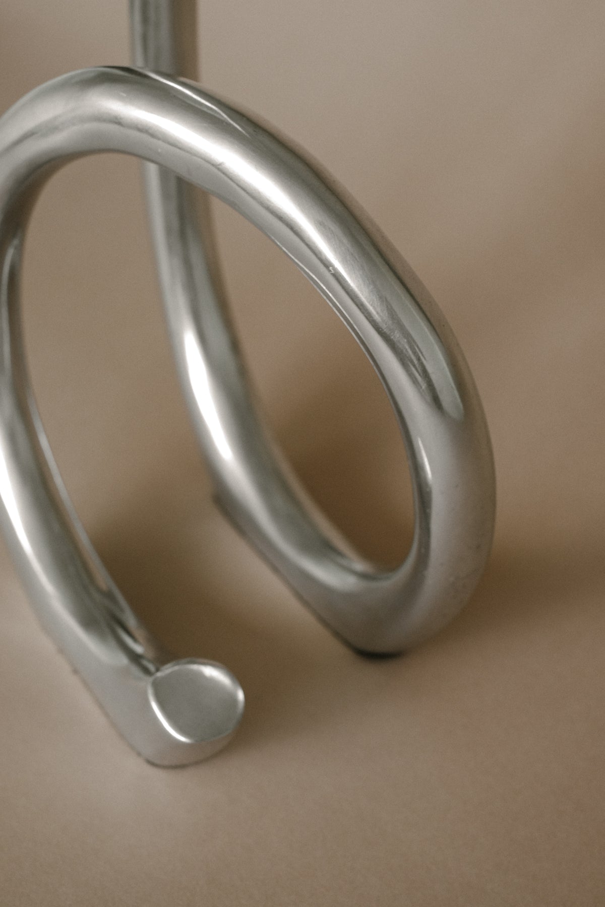 Curved metal detail of large vintage candleholder showing smooth finish