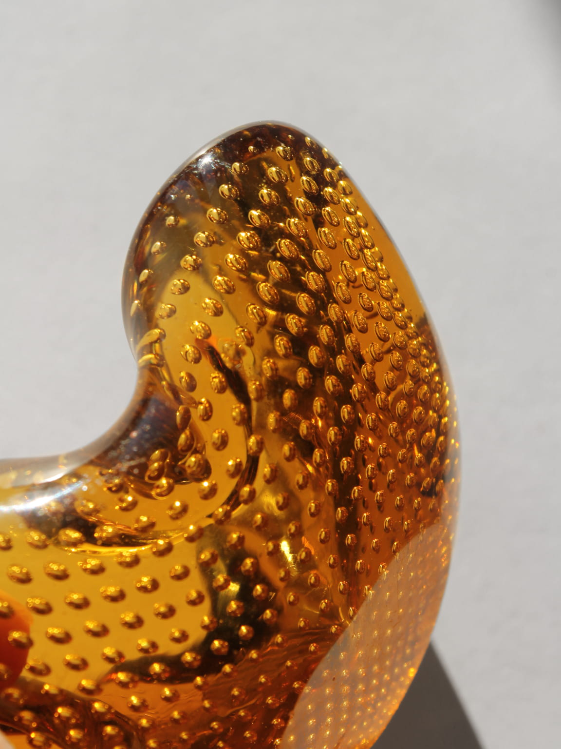 Close-up detail of amber Murano glass bubbles texture on ashtray