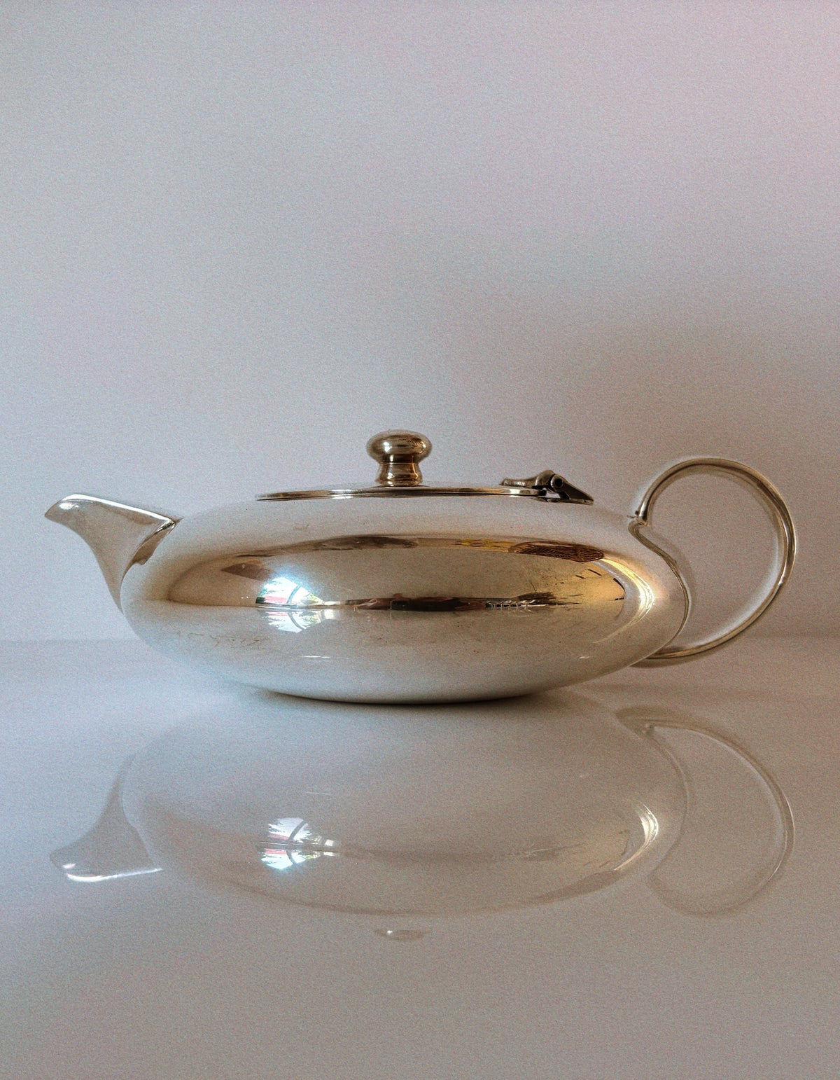 Elegant silver plated teapot with curved spout and reflective finish