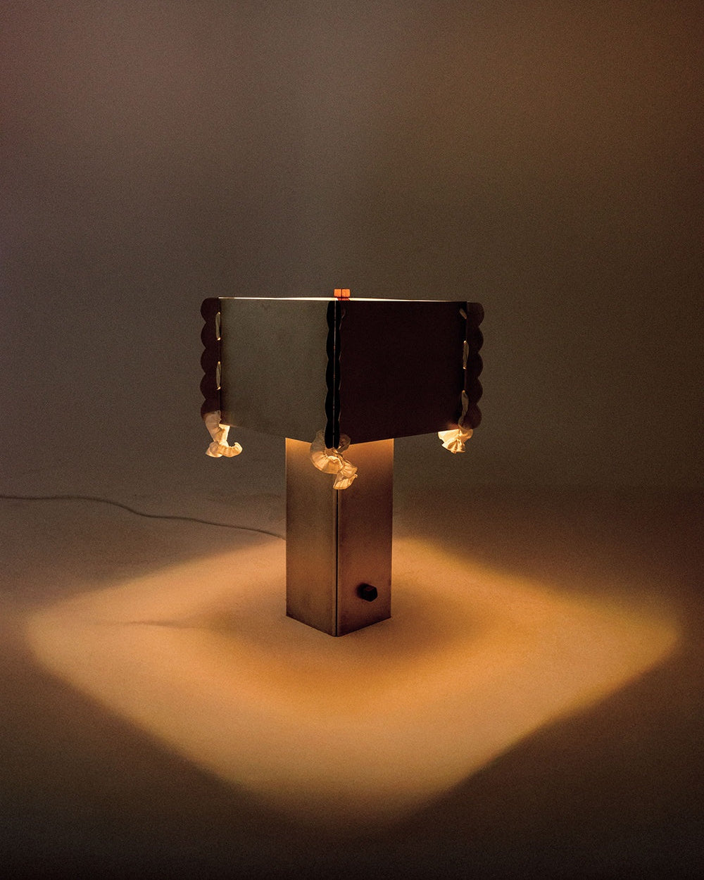 Modern sculptural table lamp with geometric bronze base and scalloped shade