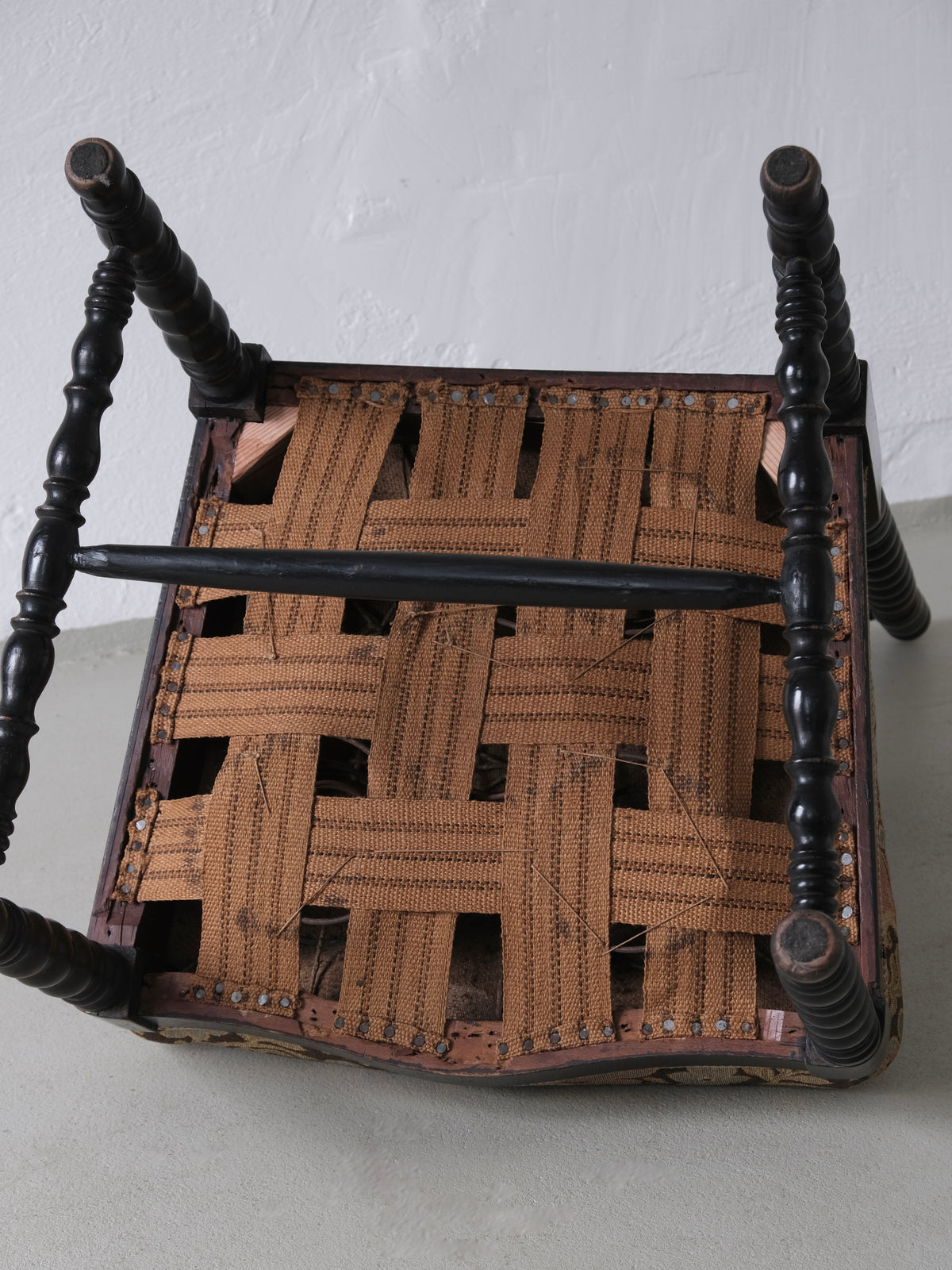 Underside view of French oak bobbin chair showing woven seat