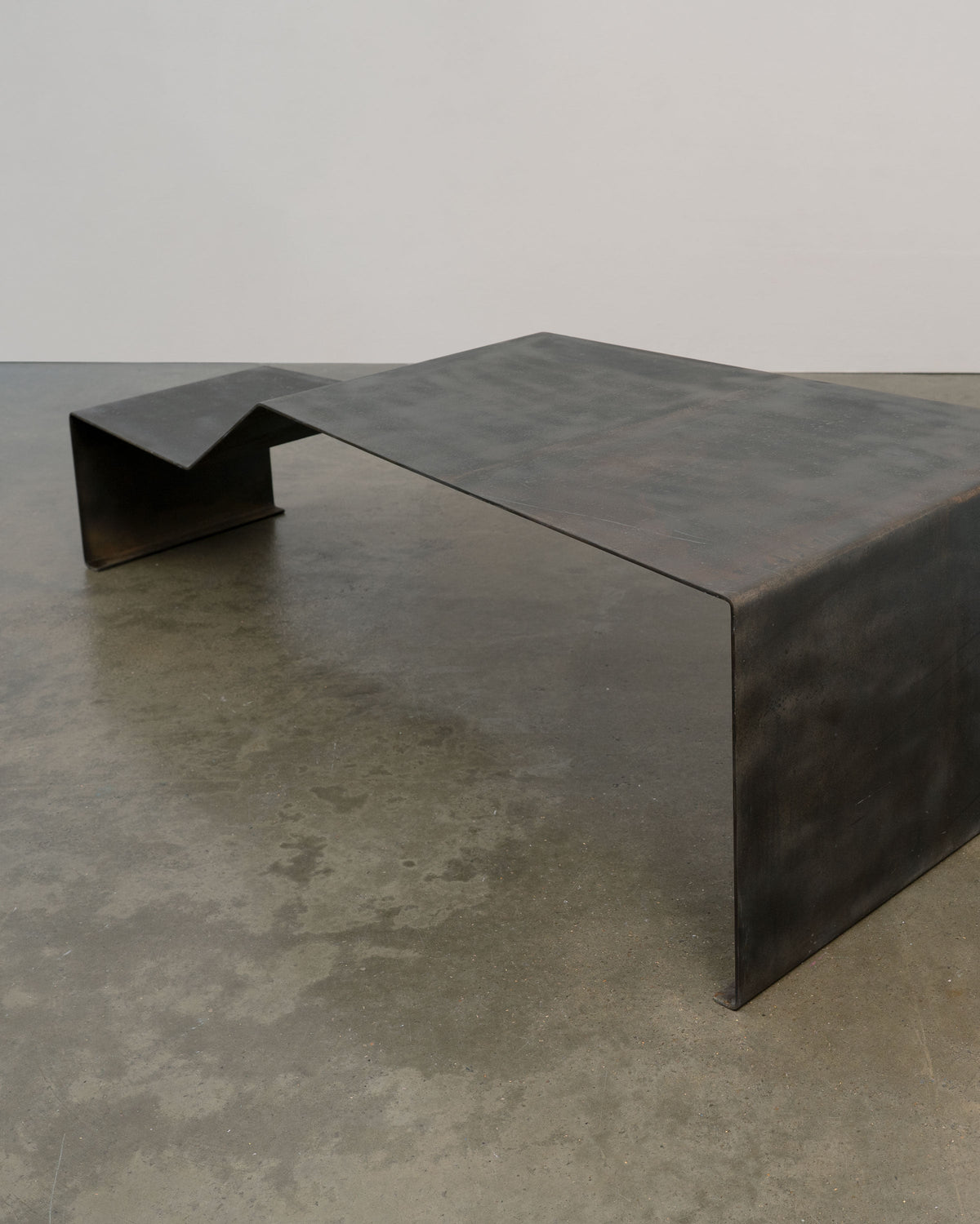 Patinated steel bench coffee table angular profile view