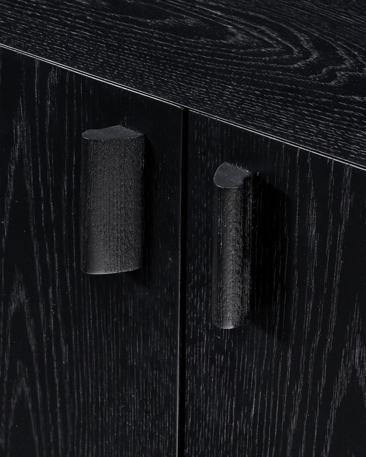 Dark wood credenza cabinet detail showing cylindrical handles and grain texture