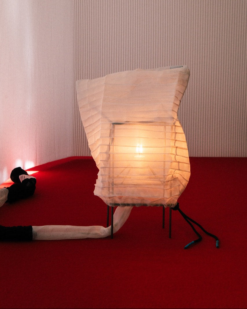 Ribbed paper table lamp with warm glow in modern red interior