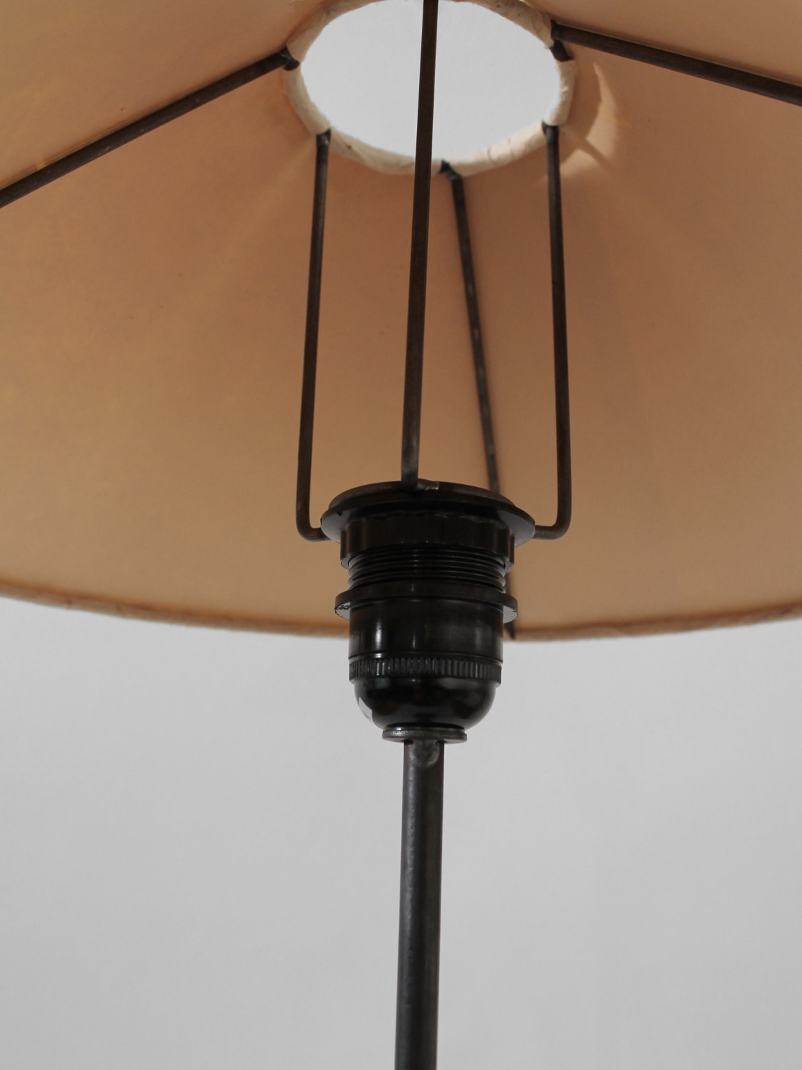 Detailed look at the underside of the Vintage Stories Mid-Century Swedish Wood And Iron Tall Lamp, highlighting its black metal socket and support rods—ideal for mid-century lighting and vintage design enthusiasts.