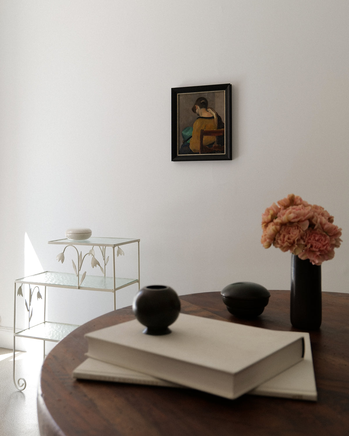 Longwy ceramic jar styled with books and flowers on round table