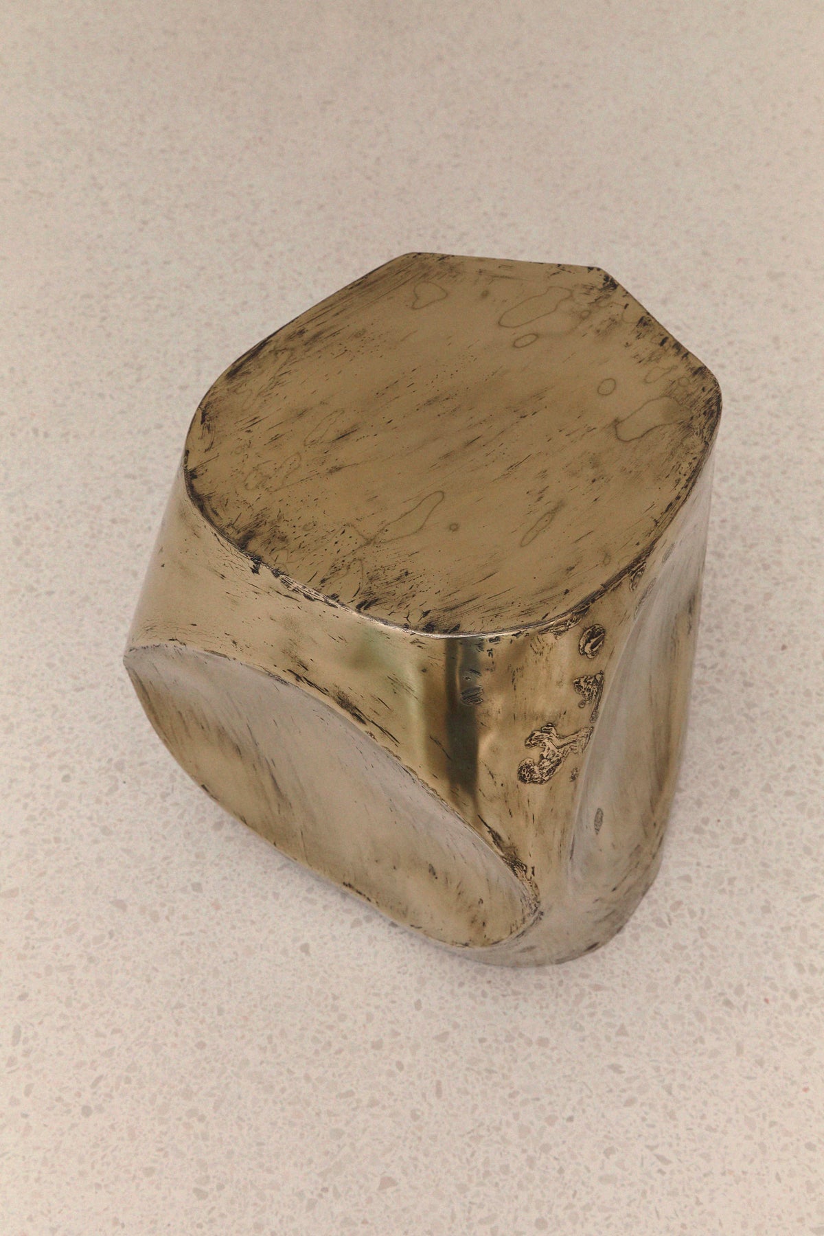 ROCHER SMALL TABLE IN POLISHED BRASS RESIN — angled view on light countertop