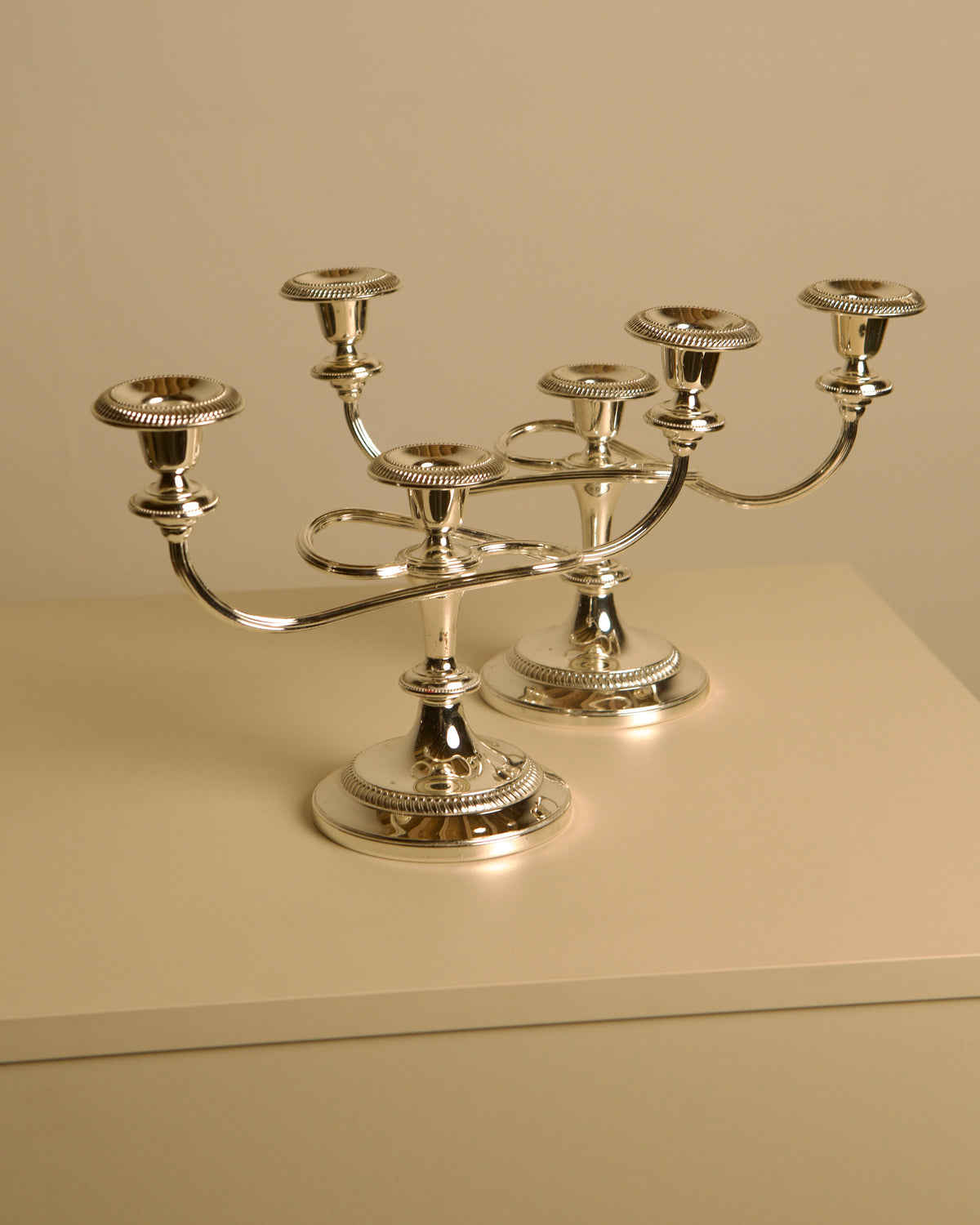 Pair of Italian metal "Medusa" candlesticks, 1980s — side view on neutral background