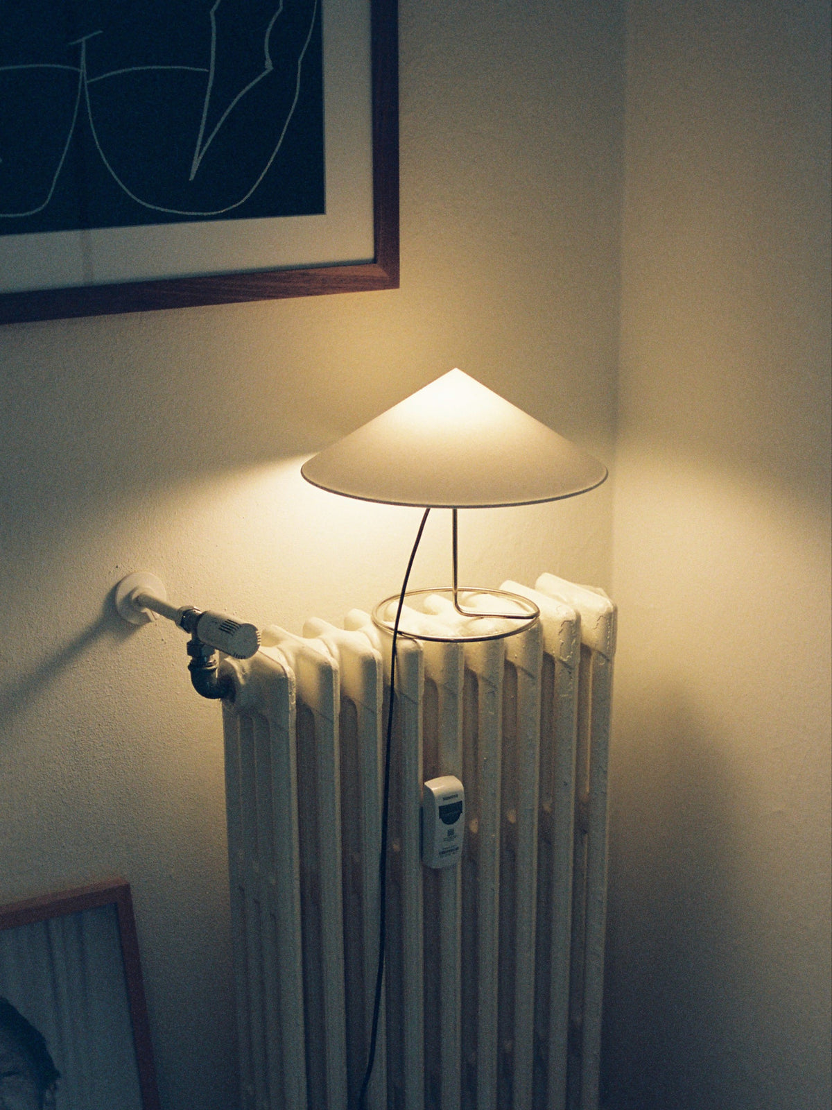 Douli Table Lamp — modern design on white radiator in cozy setting
