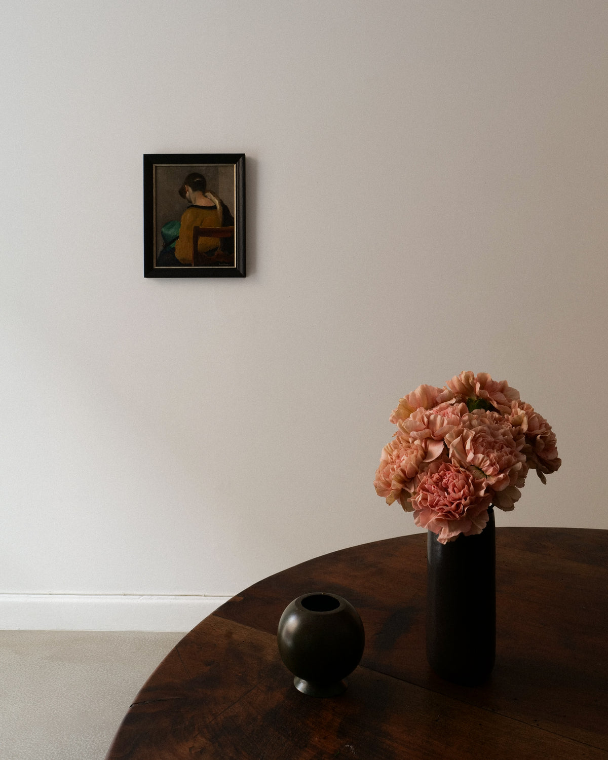 Swedish faience vase styled with pink carnations on wood table