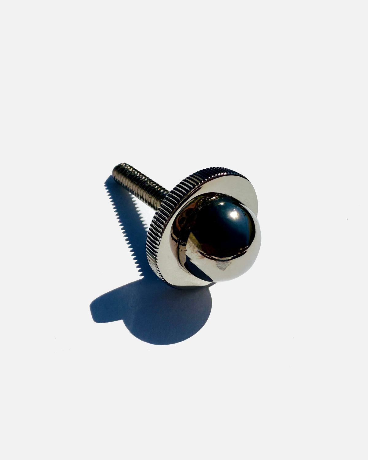 Chrome pendant light hardware detail with threaded rod and spherical fixture