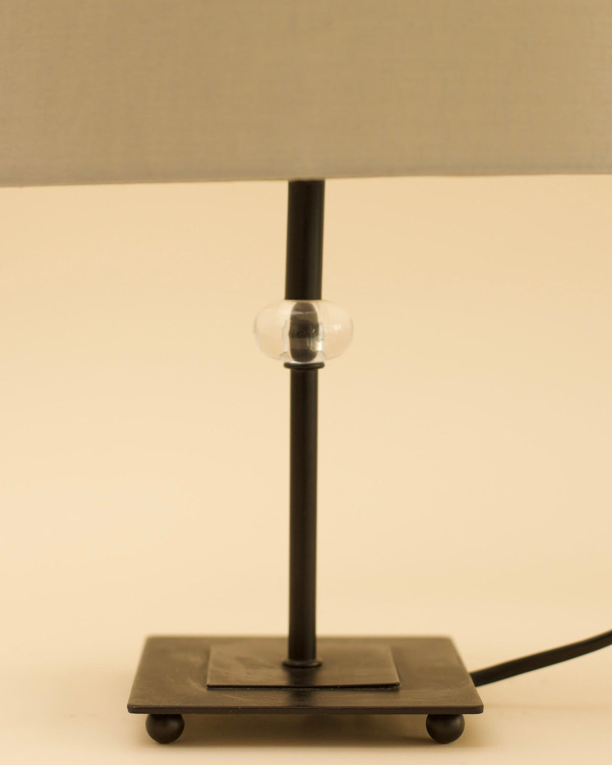 GUNTA Table Lamp — side angle showing black metal base and clear glass detail