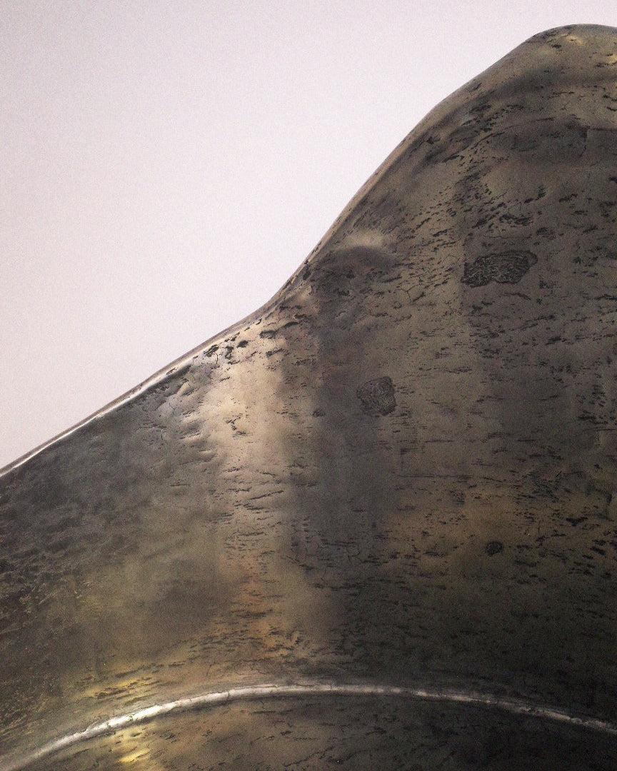 Curved aluminum-brass resin detail of AMAIA armchair surface