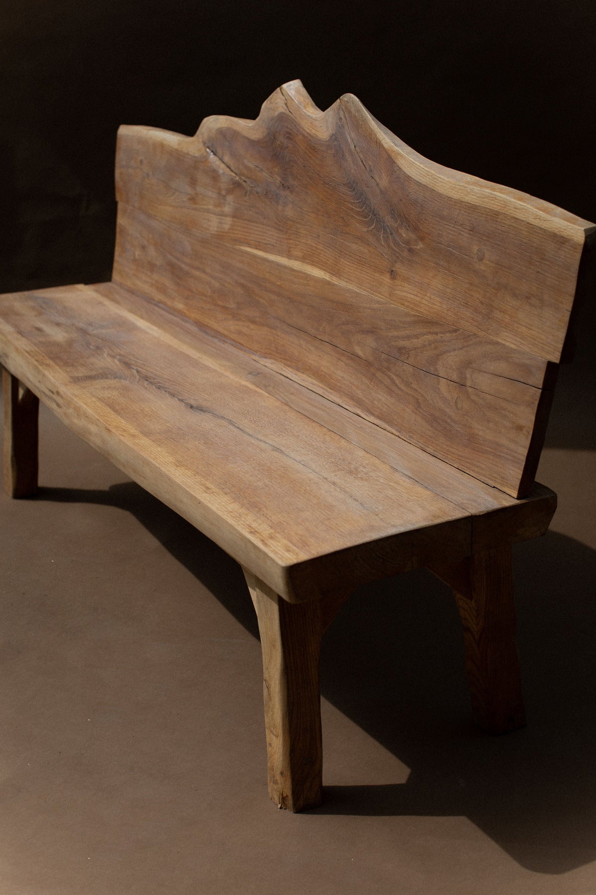 Sculptural wood brutalist bench with curved mountainous backrest