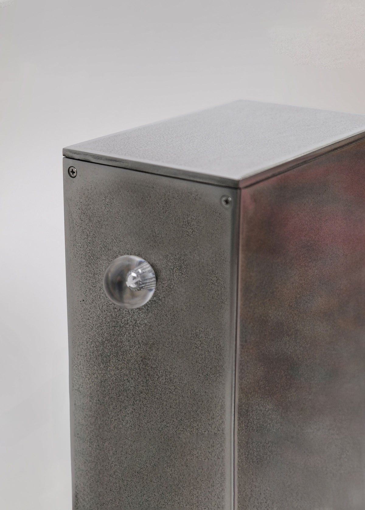 Detail view of Oblique Glow floor lamp's textured metal base with circular element