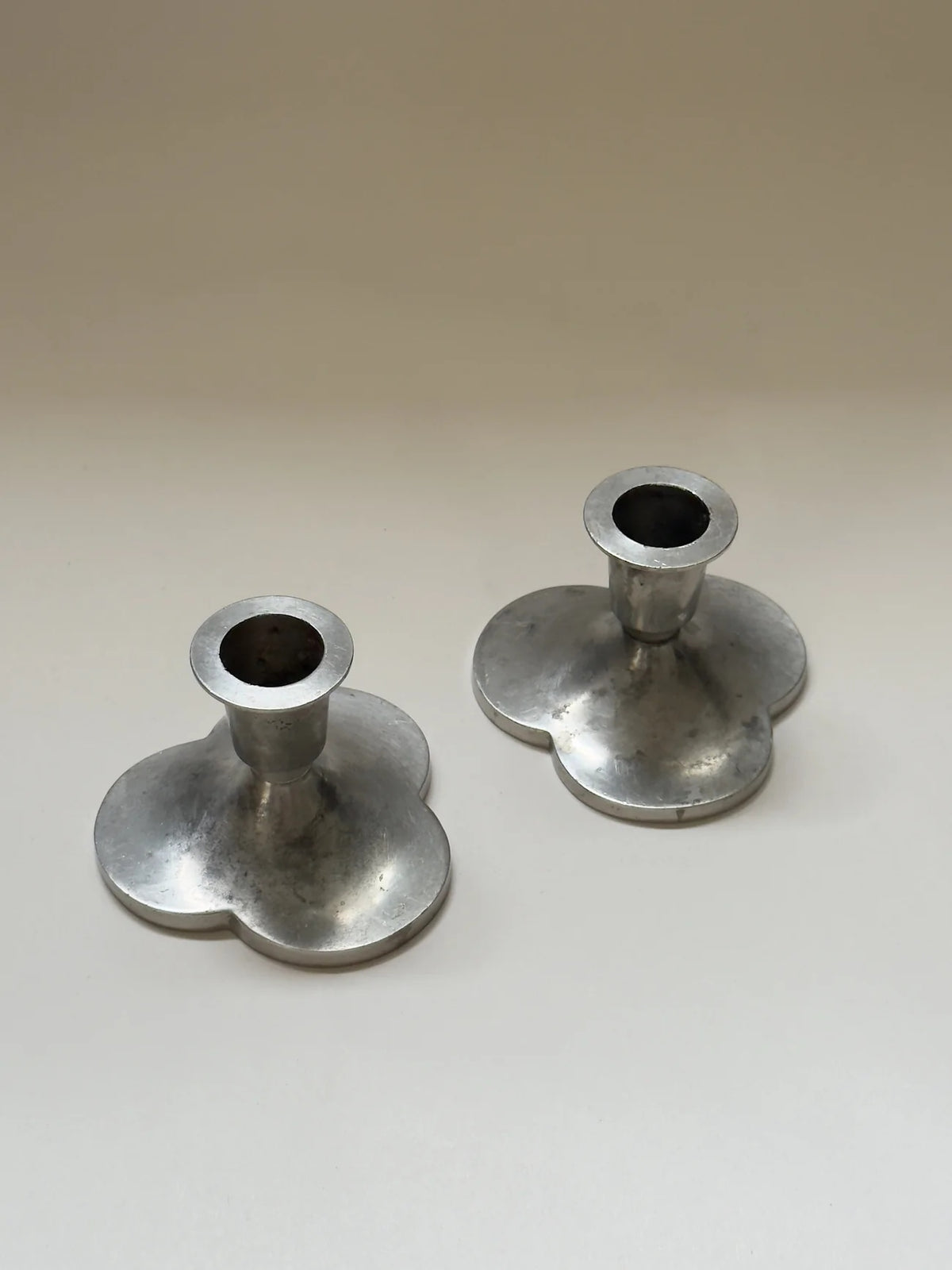 Pair of Pewter Candlesticks by Just Andersen — angled view on neutral background