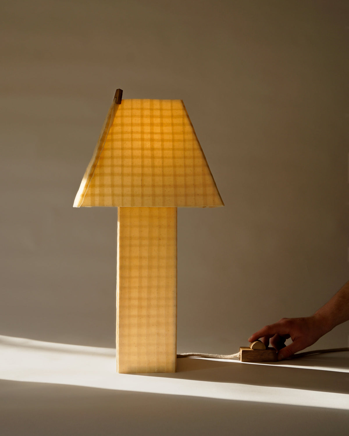 Grid table lamp with illuminated checkered shade by Basia Pruszyńska