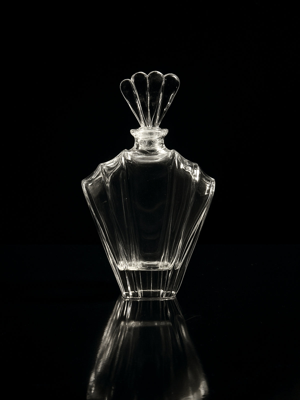 The Dodo Vintage Italian crystal Glass Art Deco Decanter from the 1980s, featuring a decorative fan-shaped stopper, is shown empty against a black background with its faint reflection visible below.