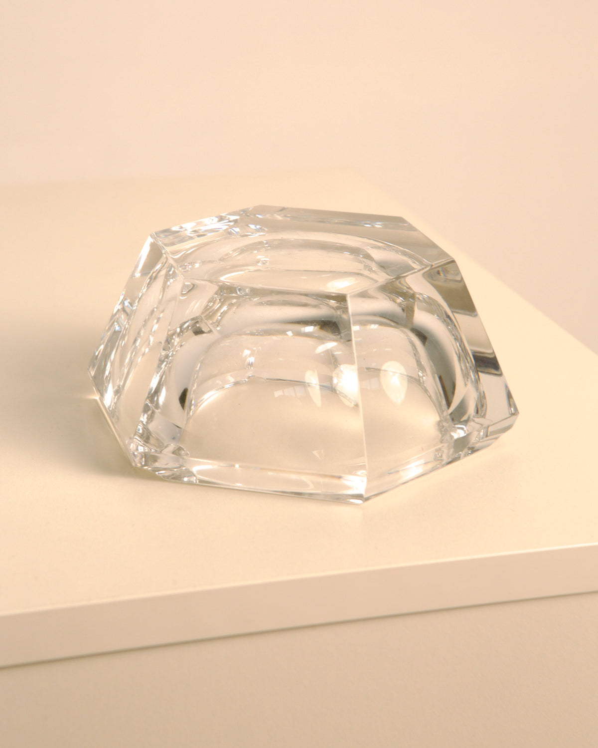 Crystal Italian ashtray with geometric faceted design on neutral surface