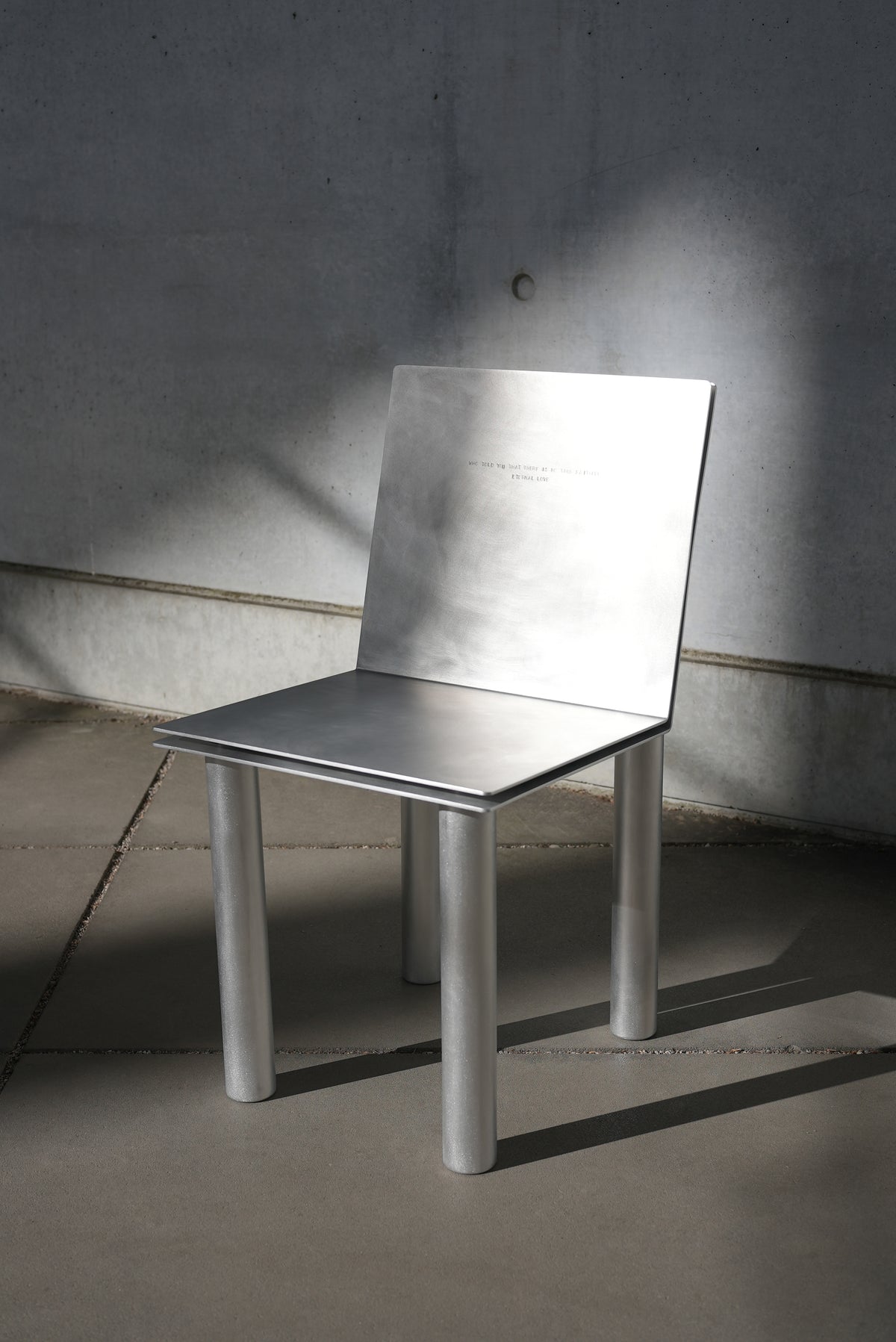 MASTER & MARGARITA — back view of aluminum chair in minimal setting
