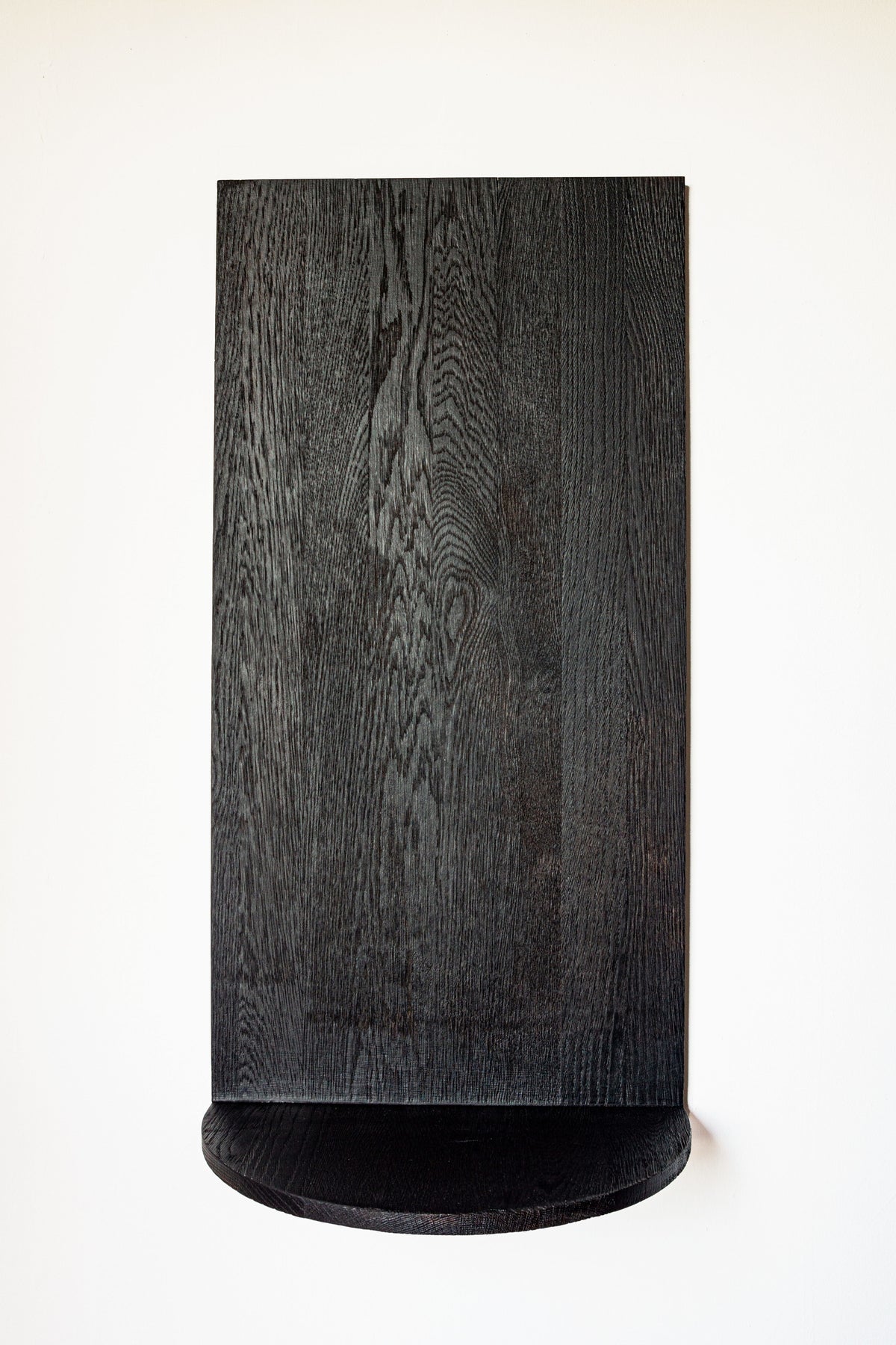 The Megaron - Minimalist Shelf in Wood - Natural Oak Large by COSEINCORSO is mounted on a white wall with a matching handcrafted rectangular solid oak panel above it, creating a modern, minimalist look.