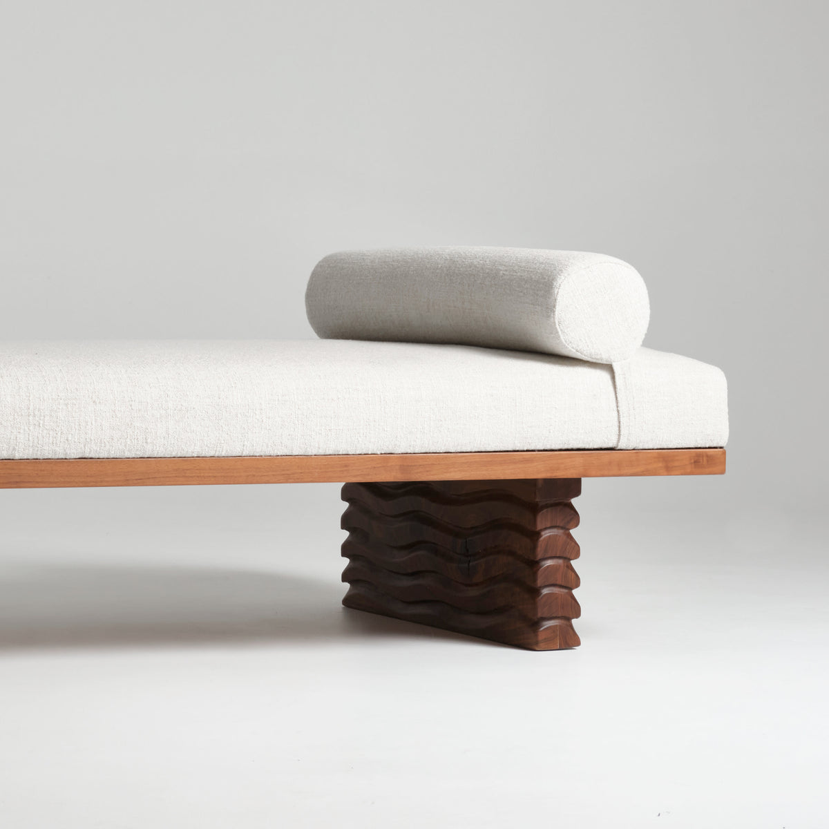 Nazaré Daybed — close-up of cream fabric and wavy wooden base