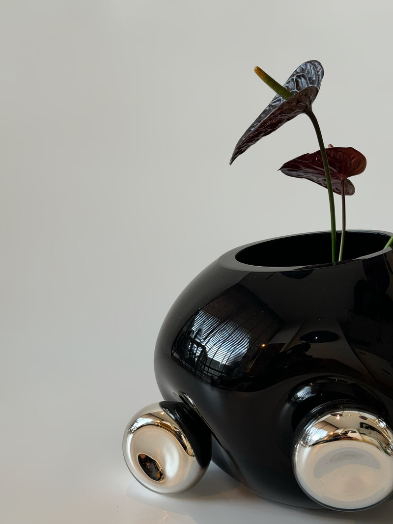 Bud Vase — close-up of glossy black ceramic with silver accents