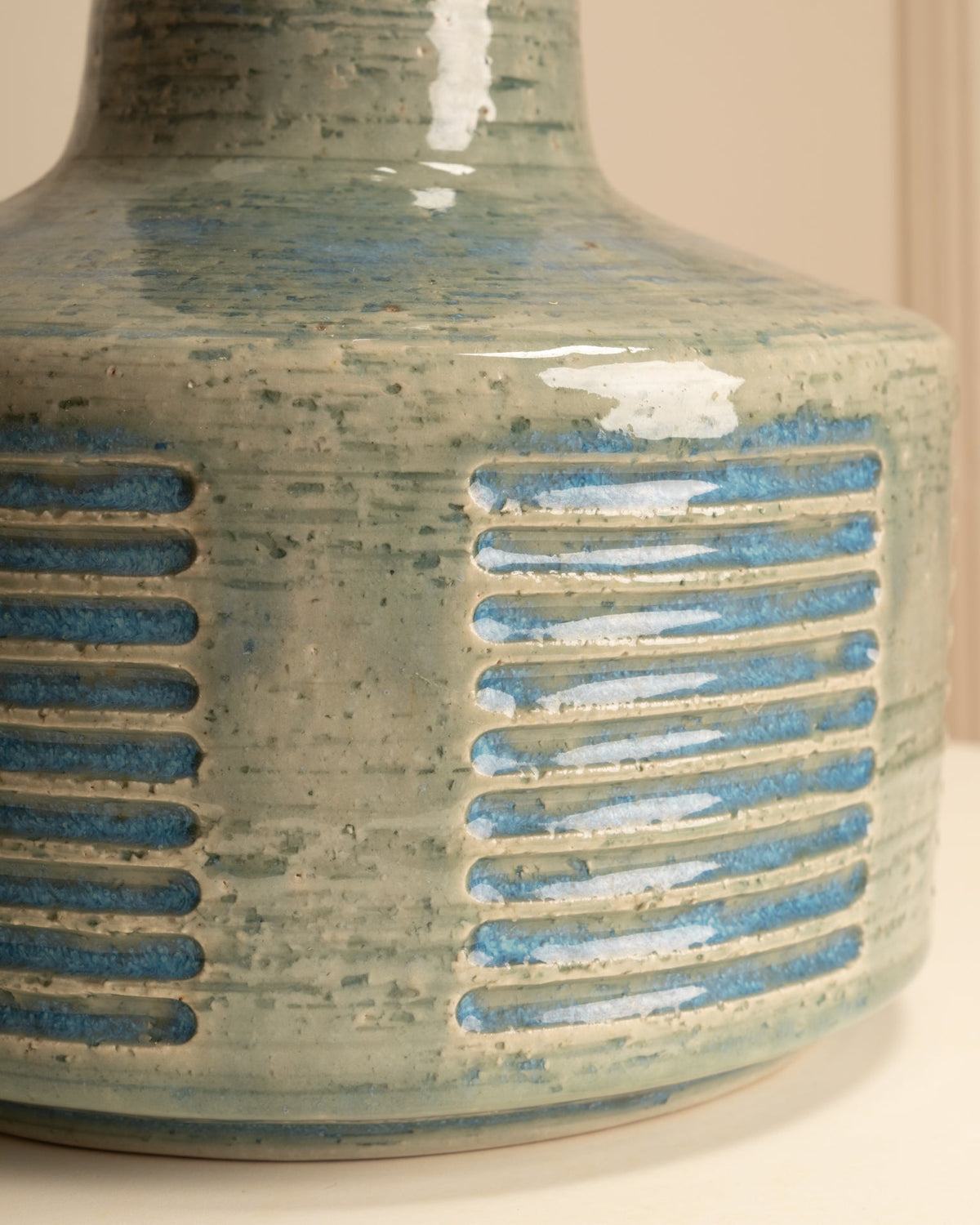 Close-up detail of glazed ceramic with horizontal blue stripes