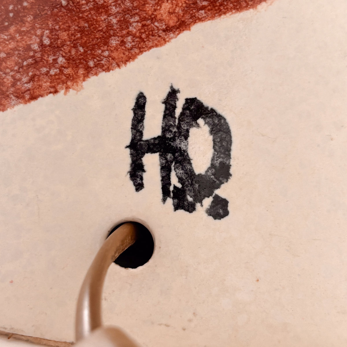 Ceramic lamp base detail showing "HO" artist signature marking