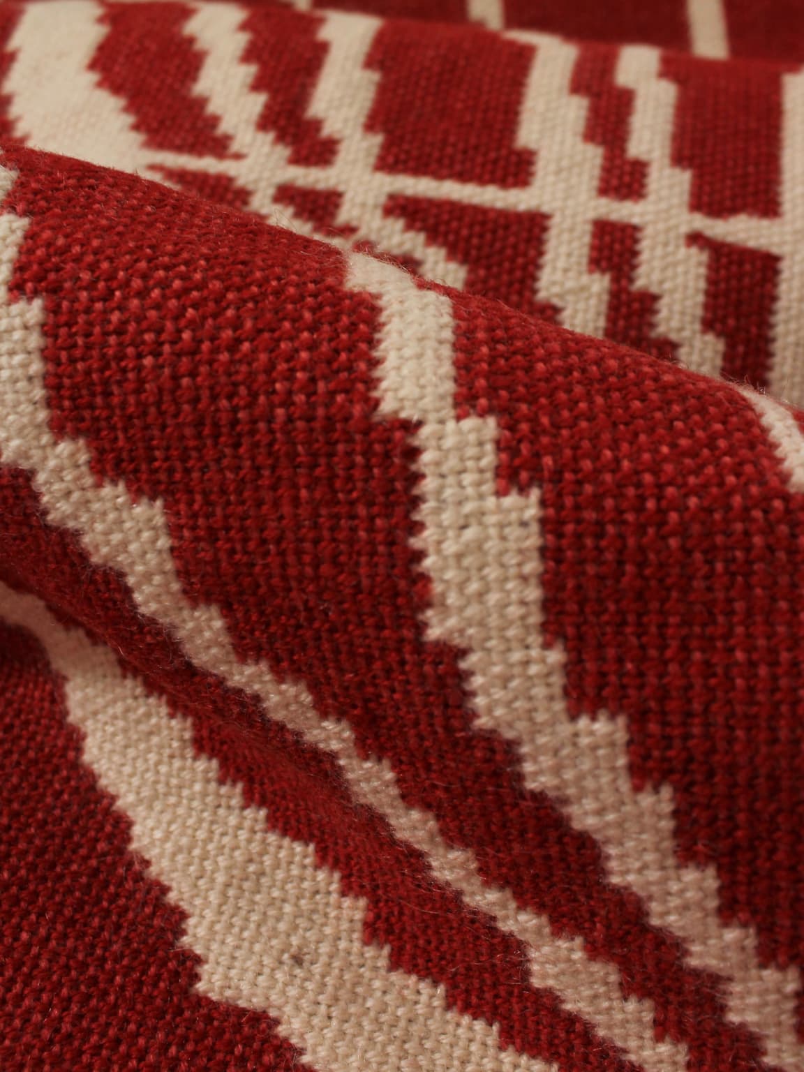 Close-up of the Red Wool Wall Tapestry With Abstract Nature Motifs by Vintage Stories (72x180cm), showcasing geometric patterns, zigzag and linear designs, and visible fabric texture.