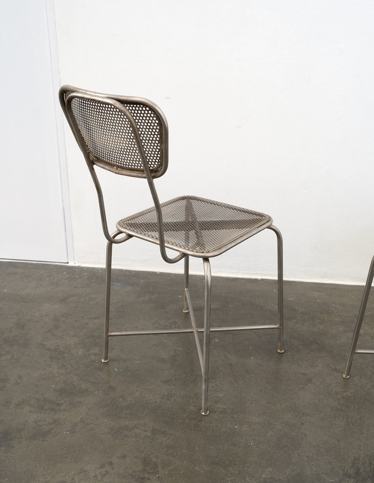 Vintage perforated metal chair back view showing mesh design