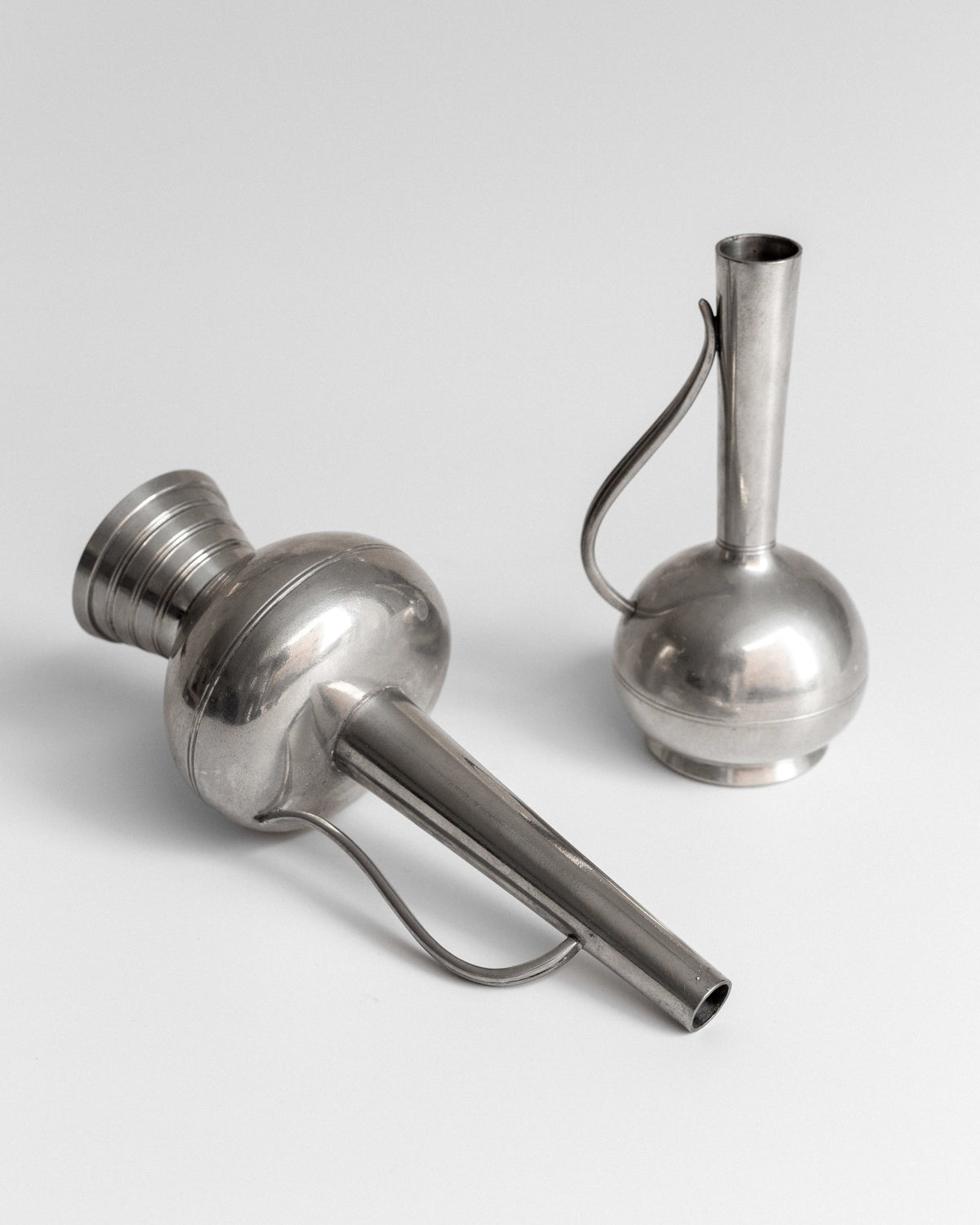 Pair of Pewter Vessels by GAB, Sweden, 1950s — angled view on white background