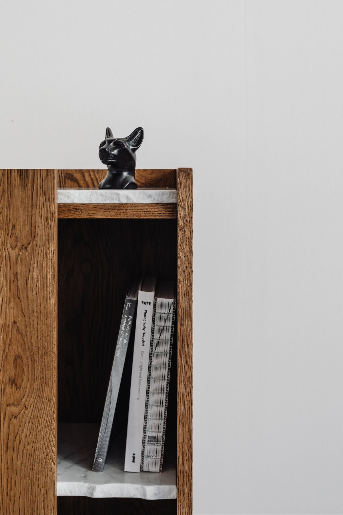 PAVO oak cabinet detail showing marble shelf and black cat sculpture on top