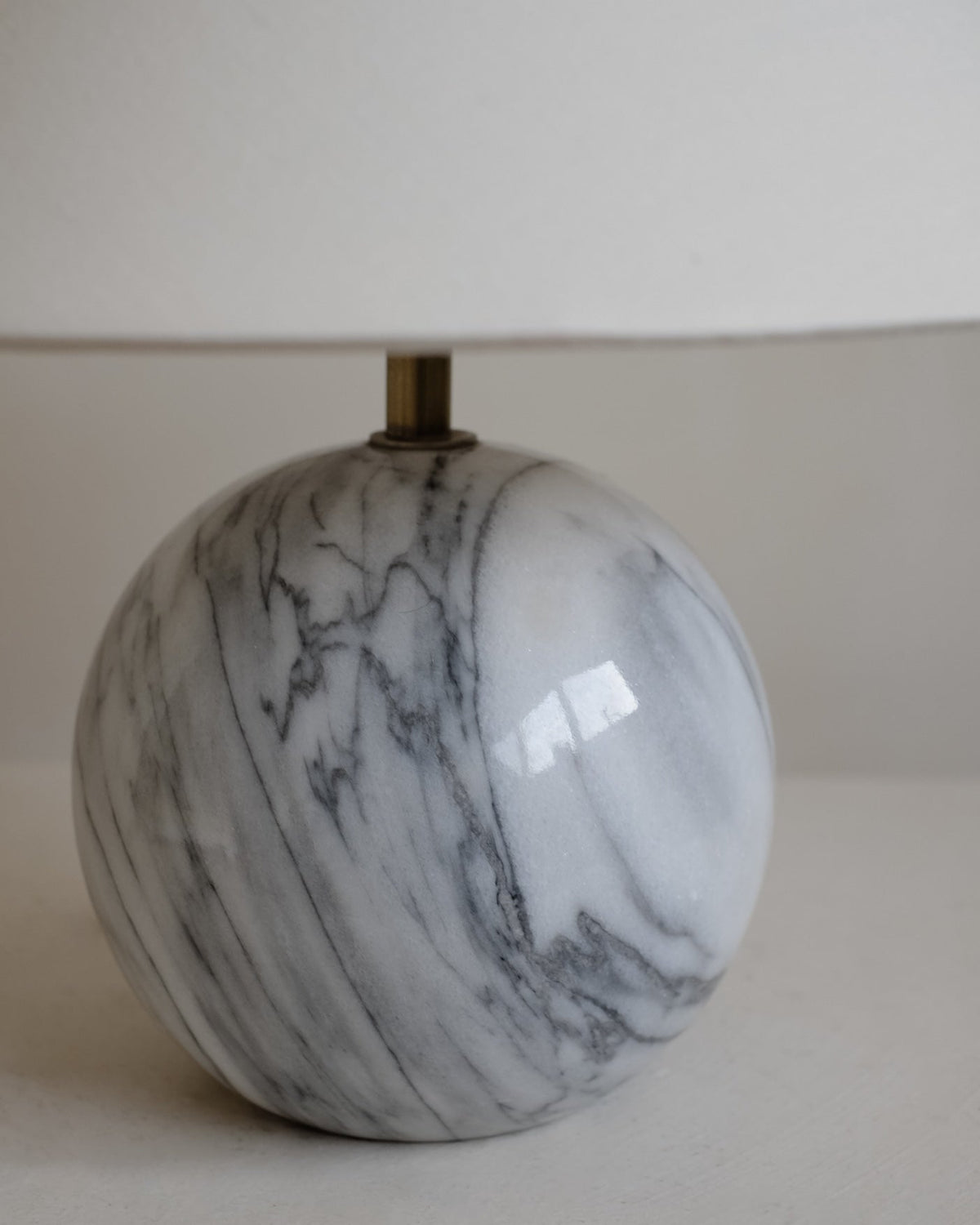 Marble Table Lamp — close-up of round marble base with white shade