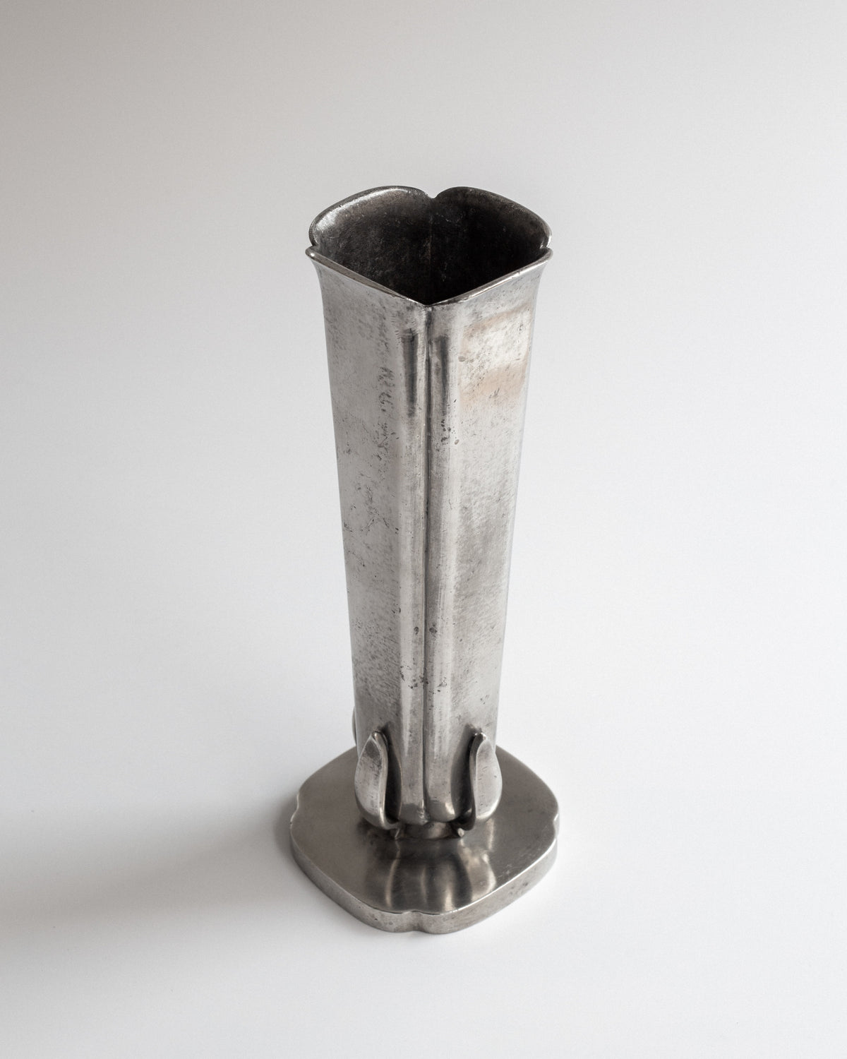 Tall pewter vase profile view showing tapered form and scalloped base