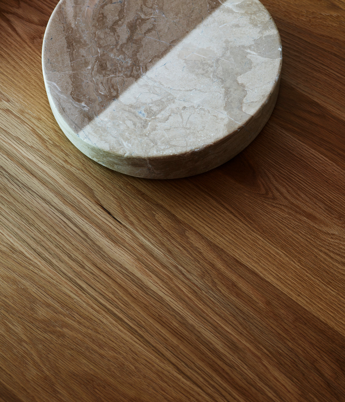 Fane marble bookstand detail showing natural stone veining on oak